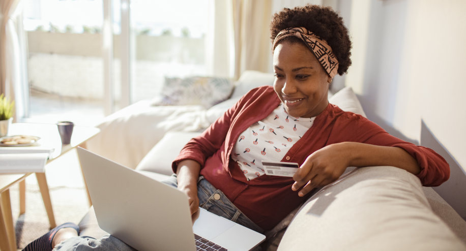 woman sitting on couch, looking at laptop